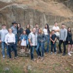 Outdoor Full family photo with adult children and their family in front of a large rock wall. Black Hills Photographer Laurel Danley