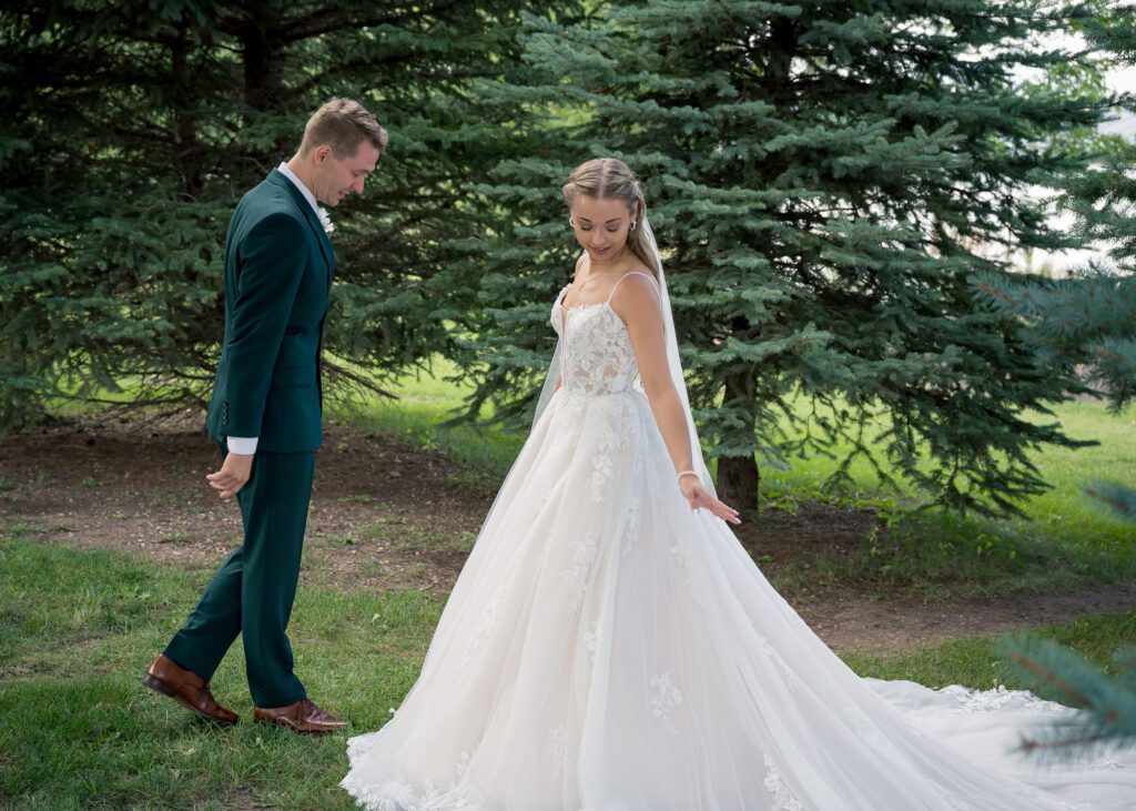 First Look Wedding Photo Groom is walking around bride to look at her dress Pixel Studios Photography Black Hills Wedding Photographer Destination Weddings